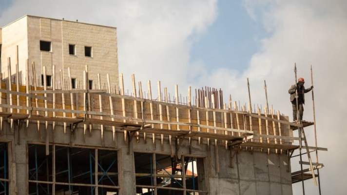 A worker on scaffolding in Efrat, West Bank